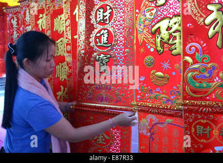 Woman hanging up Chinese New Year Festival couplets in outdoor market