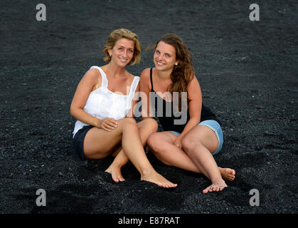 Two young women, girlfriends, on a black lava beach, Lanzarote, Canary Islands, Spain Stock Photo
