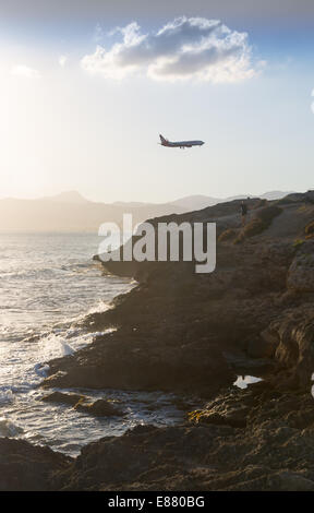 Air Berlin airliner descending into Palma de Mallorca airport. Cathedral and fishing boys in hazy summer sunset. Mallorca, Spain