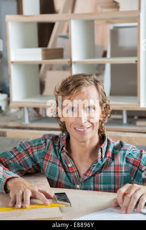 Confident Carpenter Smiling At Workbench Stock Photo