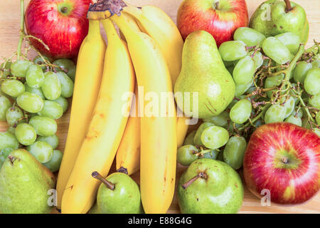 A mixture of fresh, whole fruit on a wood table Stock Photo