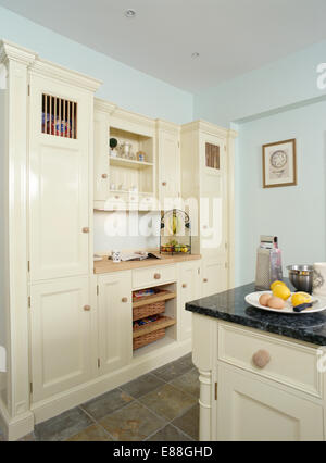 Pastel blue fitted units with granite worktops in terracotta