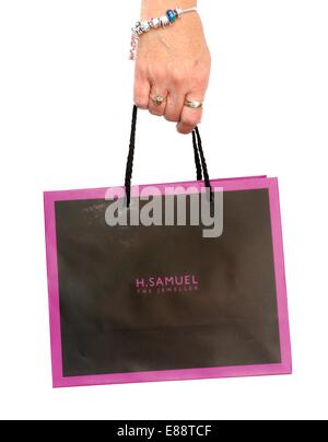 A woman carrying an H Samuel gift bag England uk Stock Photo