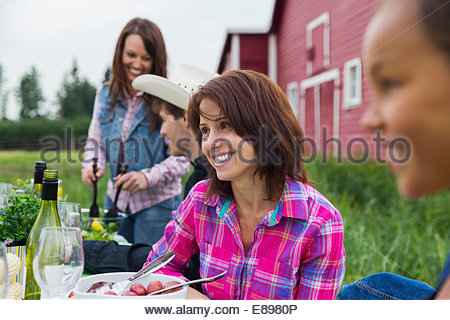 Woman enjoying family dinner outside barn