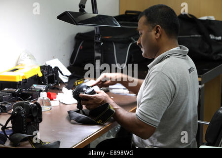 Dubai, United Arab Emirates, employees of Nikon Professional Service cleans an SLR Stock Photo