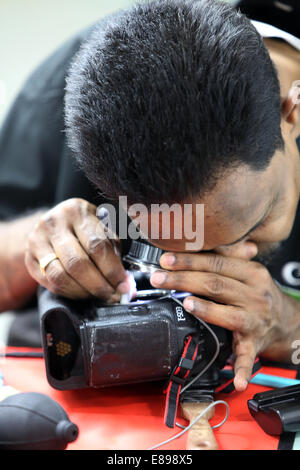 Dubai, United Arab Emirates, an employee of Canon Professional Service cleans an SLR Stock Photo