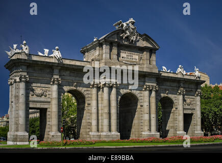 A view to the west facade of the Puerta De Alcala and it's architectural details. It is located in the center of the rotunda of the Independence Square and it is one of the five former royal gates that gave access to the city of Madrid in Spain. Stock Photo
