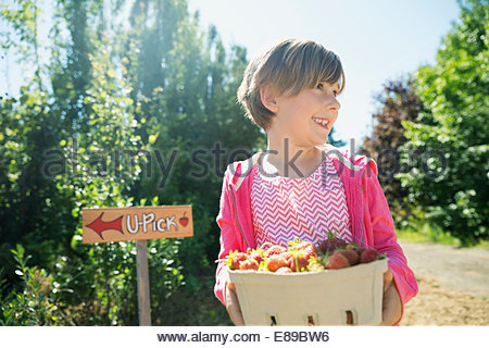 Smiling girl holding fresh picked strawberries