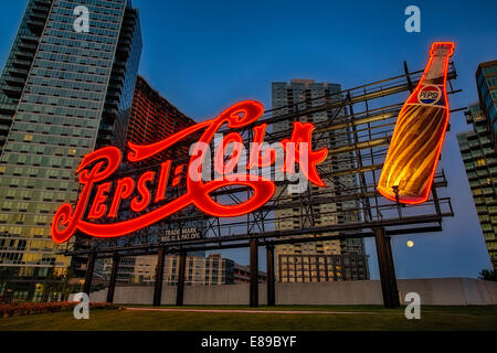 The iconic Pepsi Cola Bottling Company sign at twilight with the Gibbous Moon Rising at Gantry Plaza State Park. Stock Photo