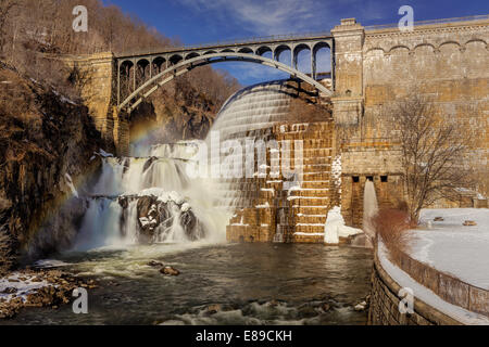 New Croton Dam waterfall also known as the Cornell Dam during a cold winter afternoon with a rainbow over the falls. The dam's construction was finalized in 1906 and it is located in Westchester County. It is part of the New York City Water Supply system. Stock Photo