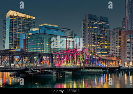 The Boston skyline during the blue hour at twilight with the Old Northern Bridge illuminated in vivid colors. Stock Photo