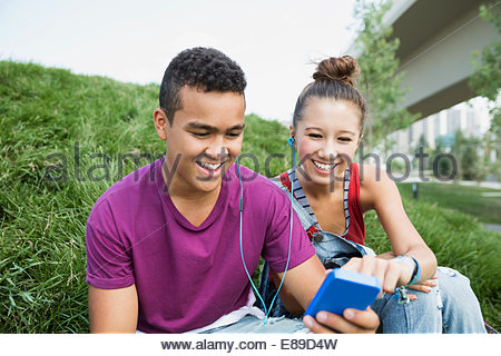 Teenage couple with mp3 player sharing headphones