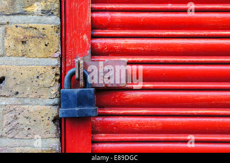 Red garage door with padlock, London England United Kingdom UK Stock Photo