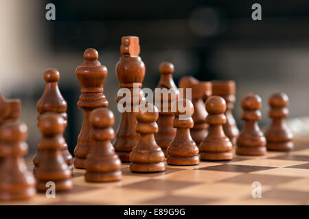 Wooden chess pieces facing off, across the games board during a match Stock Photo