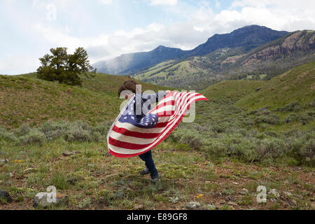 Boy holding American flag in rolling hills Stock Photo