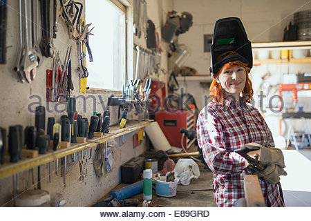Portrait of woman wearing welding mask in workshop