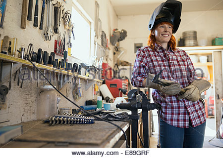 Woman wearing welding mask in workshop