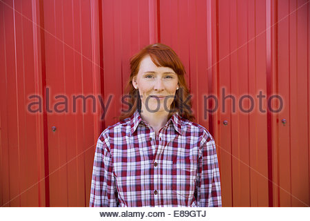 Portrait of smiling woman against red wall