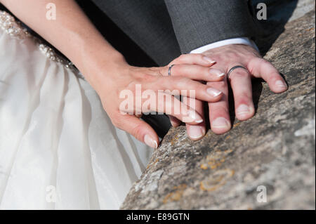 A newlywed bride lovingly touching the hand of her new husband Stock Photo