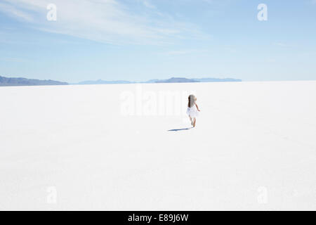 Girl running along Bonneville Salt Flats Stock Photo