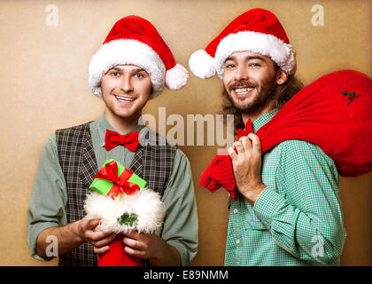 Two emotional Santa Claus  dressed in clothes hipster with the bag of the presents Stock Photo