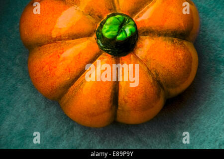 Ceramic orange pumpkin shot from above on top of a green blanket Stock Photo