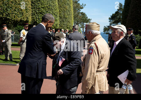 A WWII veteran kisses President Barack Obama's hand following the 70th French-American Commemoration D-Day Ceremony at the Normandy American Cemetery and Memorial in Colleville-sur-Mer, France, June 6, 2014. Stock Photo