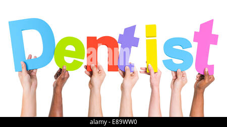Diverse Hands Holding The Word Dentist Stock Photo