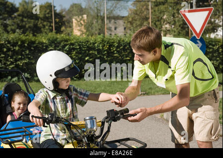 Tutor explaining quadbike to boy on driver training area Stock Photo