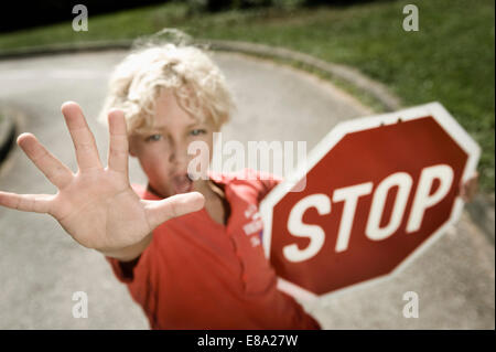 Boy on driver training area holding stop sign Stock Photo