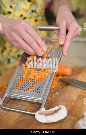 chef shredding carrots with grater in kitchen Stock Photo - Alamy