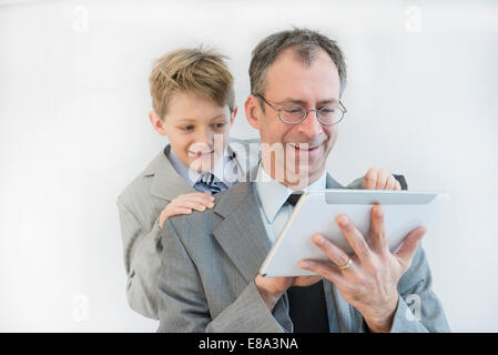 Father and son using digital tablet, smiling Stock Photo