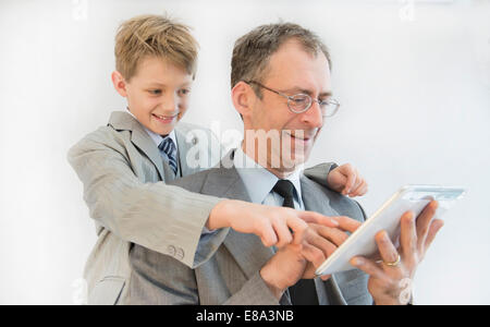 Father and son using digital tablet, smiling Stock Photo
