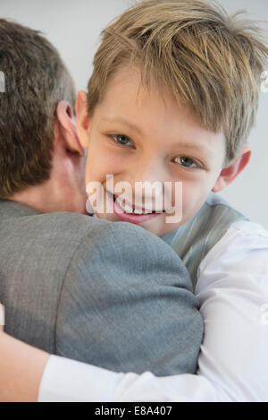 Father and son embracing each other, smiling, close up Stock Photo