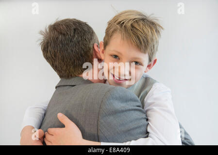 Father and son embracing each other, smiling, close up Stock Photo