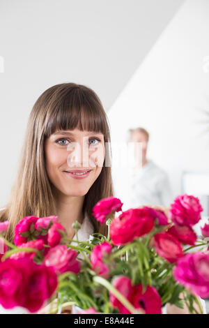 Portrait of woman with bouquet of pink flowers, smiling Stock Photo