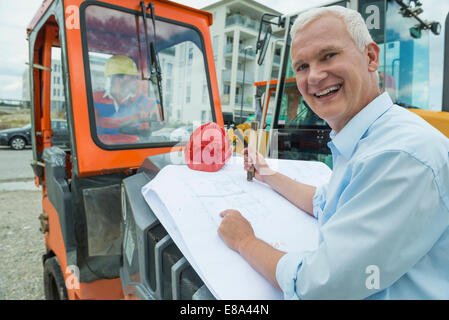 Architect checking construction plan Stock Photo