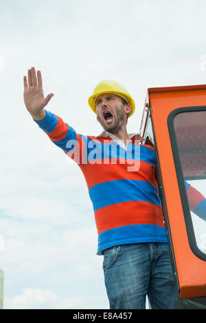 Construction worker on site with excavator Stock Photo