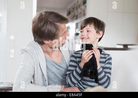Father and son looking at each other, smiling Stock Photo