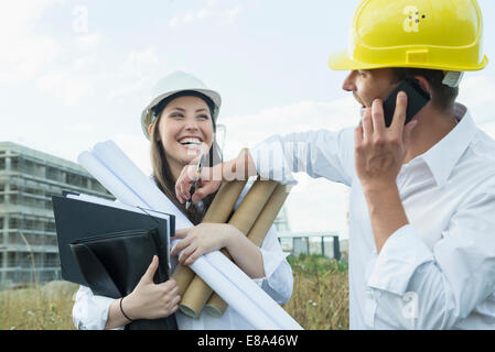 Architect on the phone, making not on construction plan Stock Photo