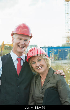 businesspeople on site wearing safety helmets Stock Photo