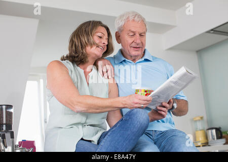 Couple drinking coffee and reading magazine at home Stock Photo
