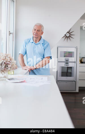 Senior man standing at the window Stock Photo