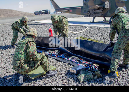 Japan Ground Self-Defense Force soldiers prepare ammunition to be loaded into the 20 mm cannon of an AH-1S Cobra helicopter Sept. 4, 2014, during Rising Thunder 2014 at the Yakima Training Center in Washington. Rising Thunder is a U.S. Army-hosted exercis Stock Photo