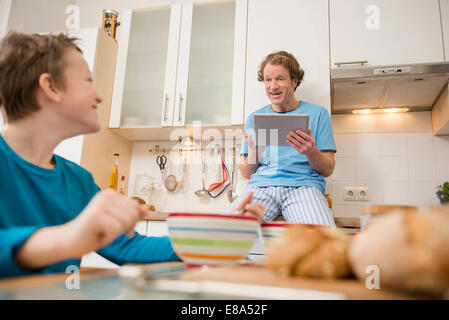 Father with digital tablet and son kitchen Stock Photo