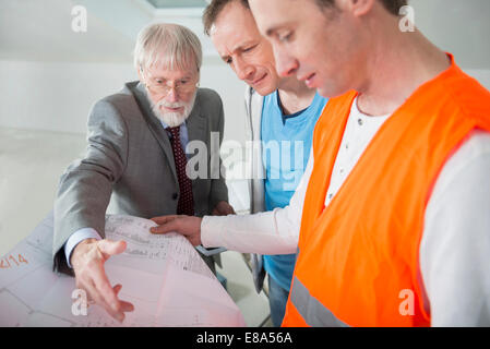 Architect, building owner and construction worker at construction site of new building Stock Photo