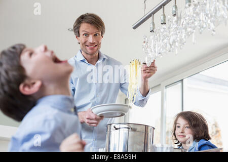 Father hand overing meal to childrens Stock Photo