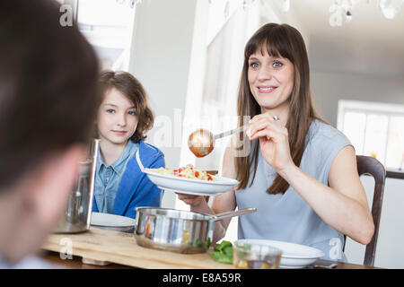 Mother hand overing meal to childrens Stock Photo