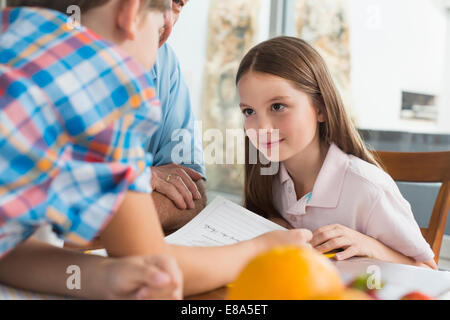 Children doing homework with their grandfather Stock Photo