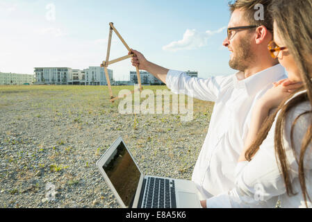 Happy couple with laptop at development area Stock Photo